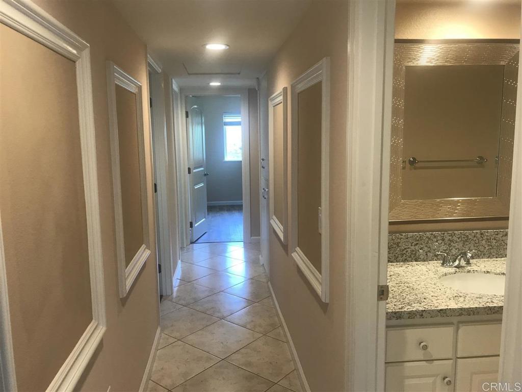 11417 Poblado Road San Diego, CA 92127 - Photo 13 of 37 a view of hallway with walk in closet and wooden floor