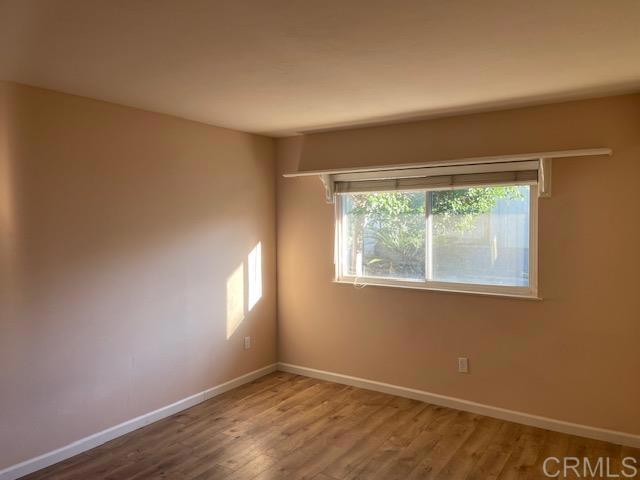 11417 Poblado Road San Diego, CA 92127 - Photo 17 of 37 a view of an empty room with wooden floor and a window