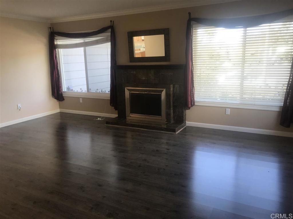 11417 Poblado Road San Diego, CA 92127 - Photo 9 of 37 a view of a livingroom with wooden floor a fireplace and windows