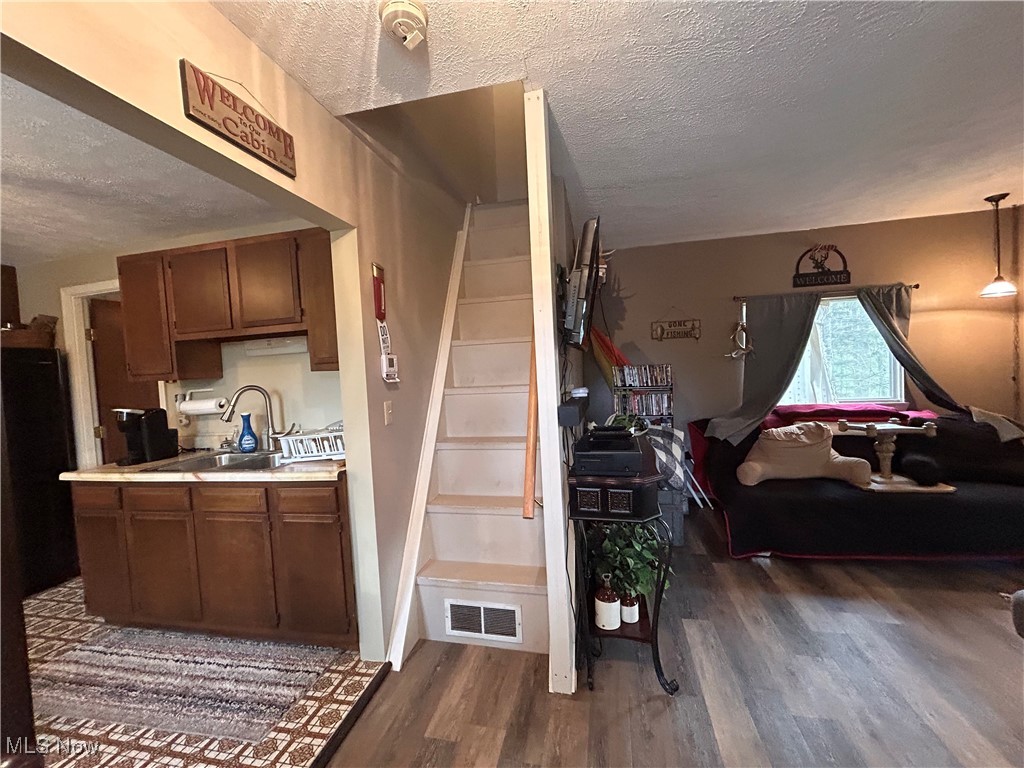 32290 Richey Lane Freeport, OH 43973 - Photo 10 of 20 Stairs featuring wood finished floors, a textured ceiling, and visible vents