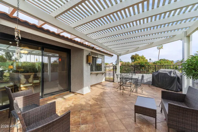 a view of a patio with table and chairs with wooden floor and fence