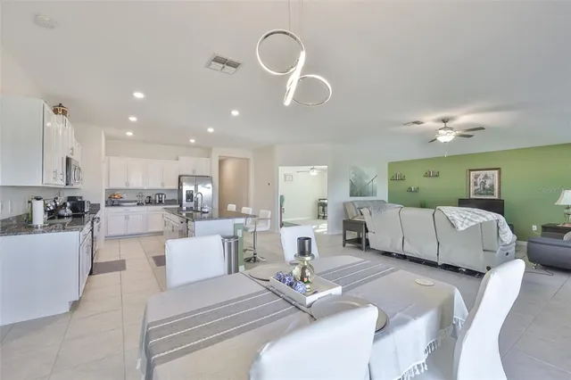 a living room with furniture chandelier and kitchen view