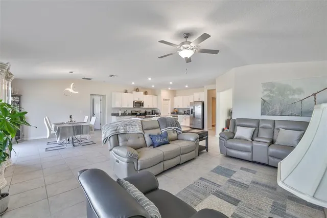 a living room with furniture and a view of kitchen