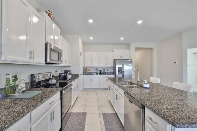 a large kitchen with granite countertop lots of counter space and sink