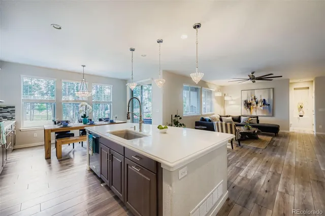 a large kitchen with kitchen island a stove a table a sink a refrigerator and chandelier