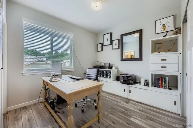 a view of a workspace with furniture and a window