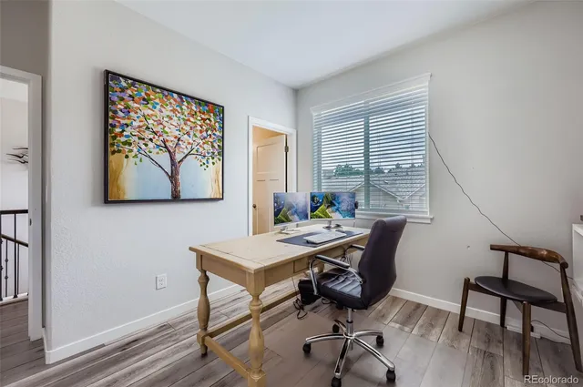 a view of a workspace with furniture and a window