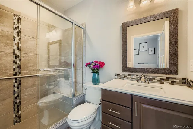 a bathroom with a sink vanity mirror and toilet