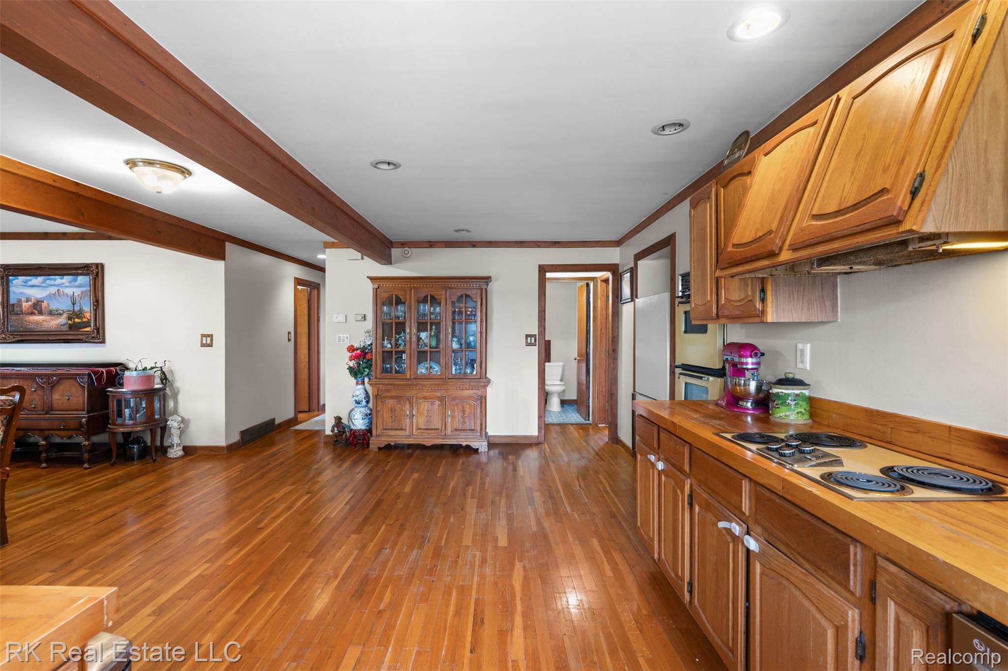 13799 31 Mile Road Washington, MI 48095 - Photo 13 of 40 Kitchen featuring wood finish cabinetry, light wood-type flooring, stainless steel electric stovetop, ornamental molding, and recessed lighting
