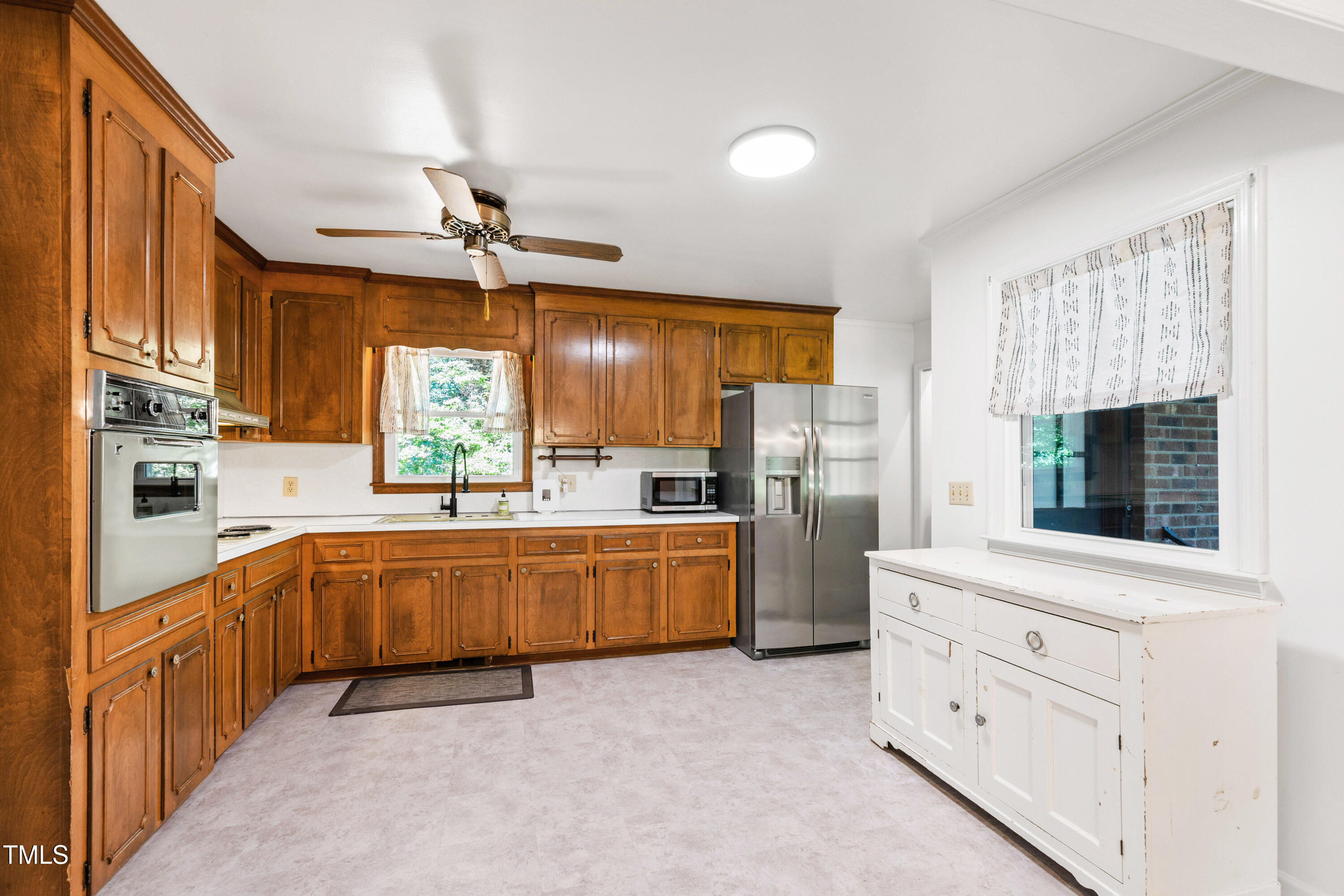 4606 Greenbrier Road Raleigh, NC 27603 - Photo 13 of 49 a large kitchen with white cabinets and stainless steel appliances