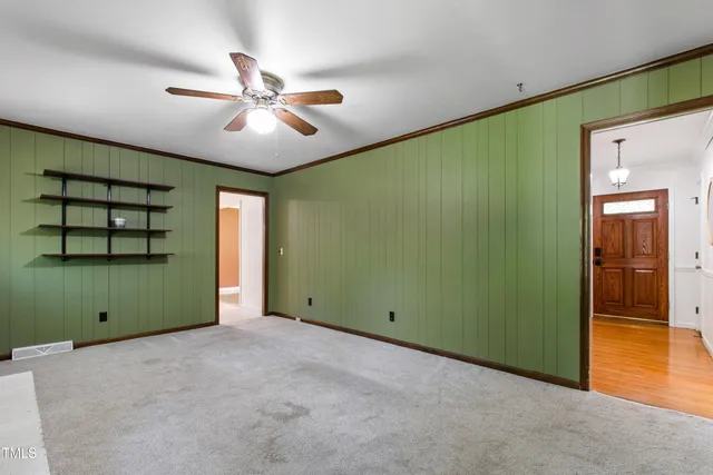 a view of a room with a large window and a ceiling fan