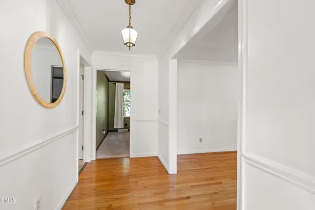 a view of a hallway with wooden floor and a chandelier