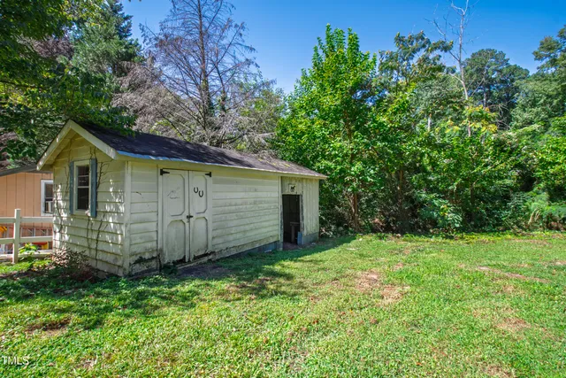 a view of a house with backyard and a tree