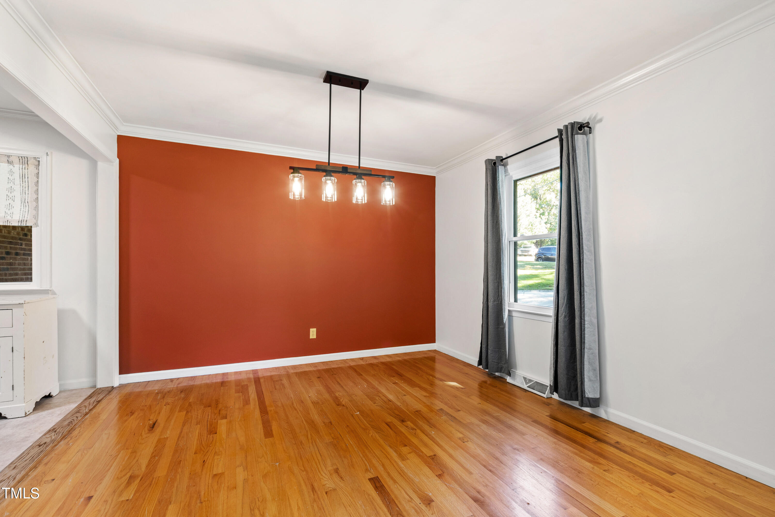 4606 Greenbrier Road Raleigh, NC 27603 - Photo 8 of 49 a view of an empty room with window and wooden floor