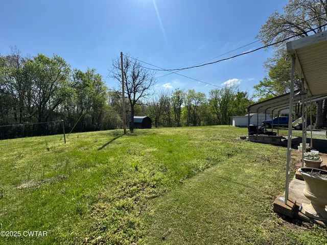 a view of a backyard with a garden and entertaining space