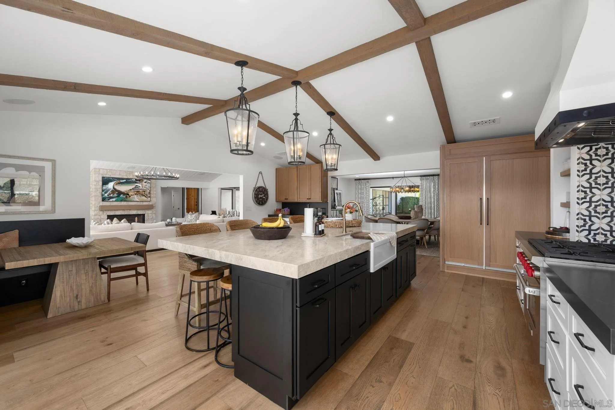 5424 El Cielito Rancho Santa Fe, CA 92067 - Photo 9 of 22 a large kitchen with stainless steel appliances a stove a sink dishwasher and a dining table with wooden floor