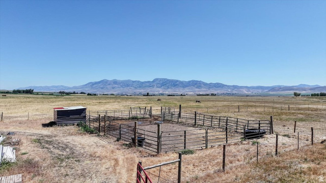 1634 West Arimo Road Arimo, ID 83214 - Photo 63 of 89 Expansive fenced enclosure with a small shelter on a large rural property, featuring a distant mountain range backdrop