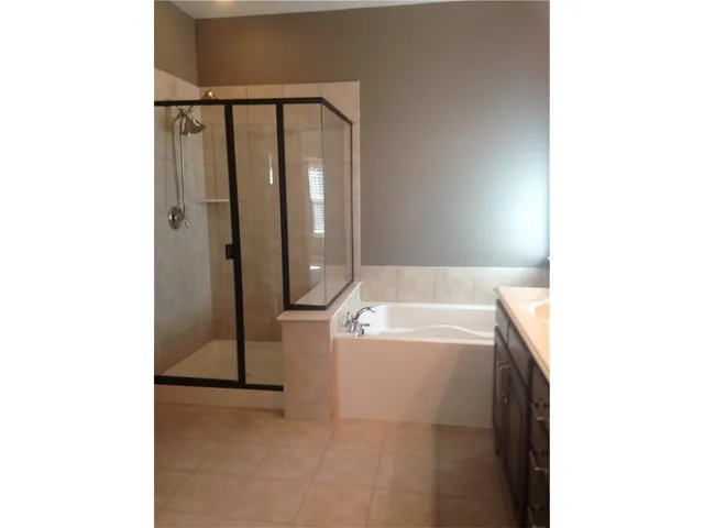 a bathroom with a tub a sink and a shower