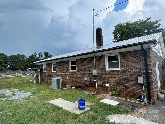 a backyard of a house with barbeque oven table and chairs