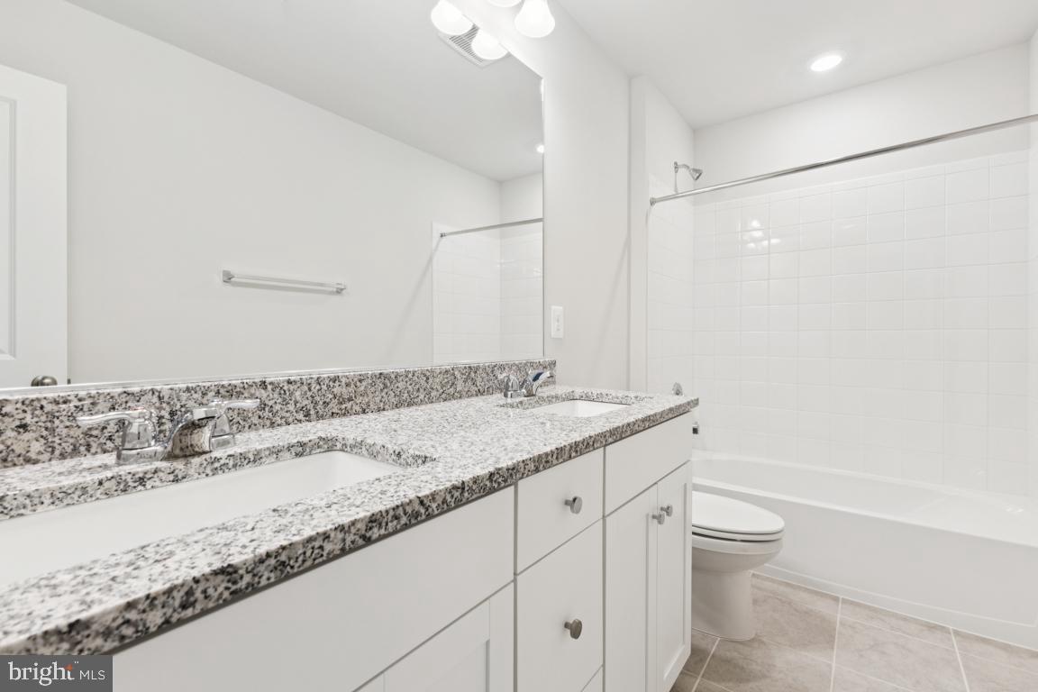 9656 Killenney Place Waldorf, MD 20601 - Photo 17 of 25 a bathroom with a granite countertop sink a toilet and shower