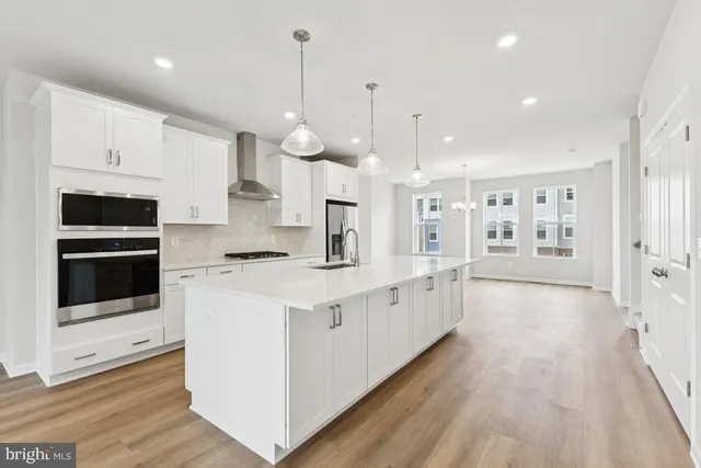 a large white kitchen with stainless steel appliances