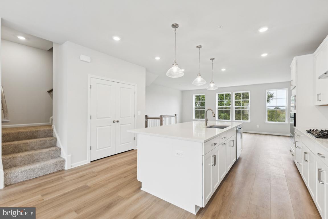9656 Killenney Place Waldorf, MD 20601 - Photo 4 of 25 a large white kitchen with wooden floor and a sink