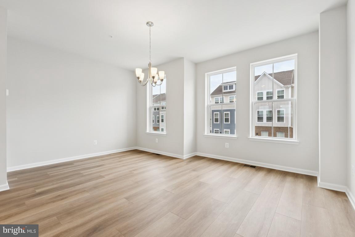 9656 Killenney Place Waldorf, MD 20601 - Photo 6 of 25 a view of an empty room with wooden floor and a window