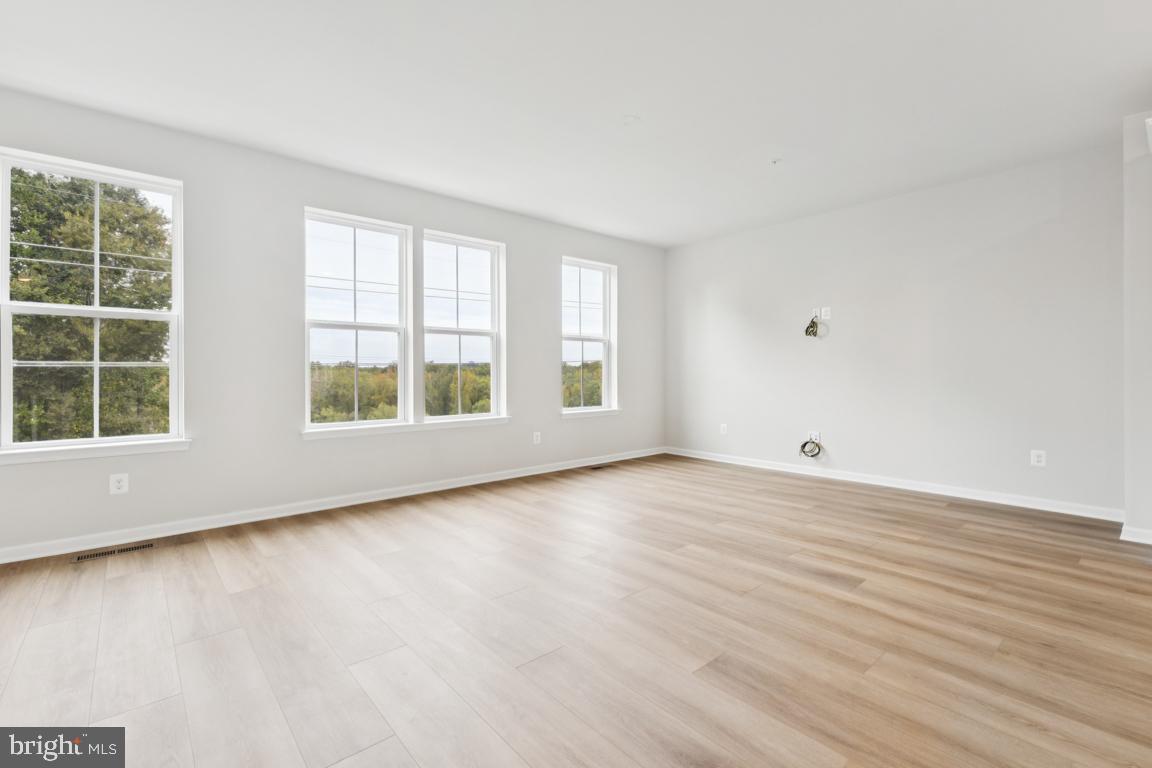 9656 Killenney Place Waldorf, MD 20601 - Photo 9 of 25 an empty room with wooden floor and windows