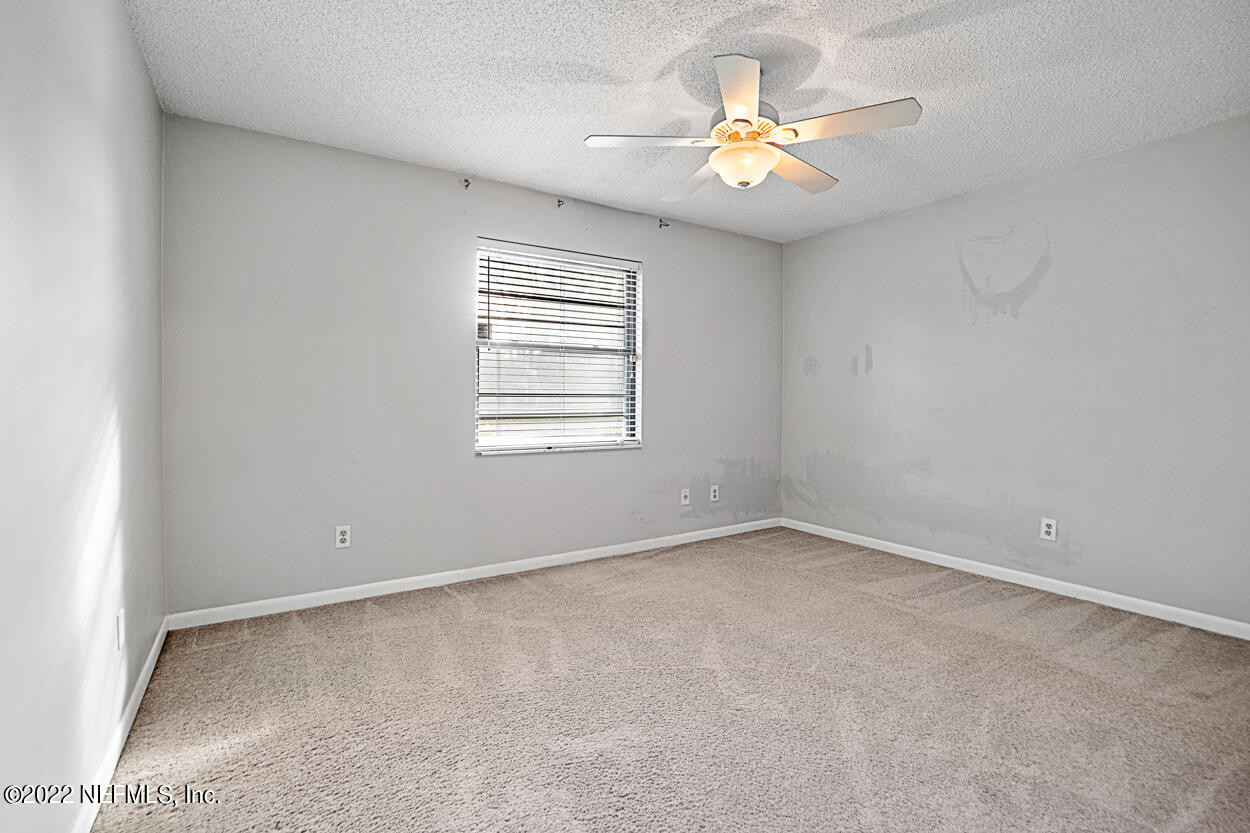 3759 Rustic Lane Jacksonville, FL 32217 - Photo 19 of 32 an empty room with windows and chandelier fan