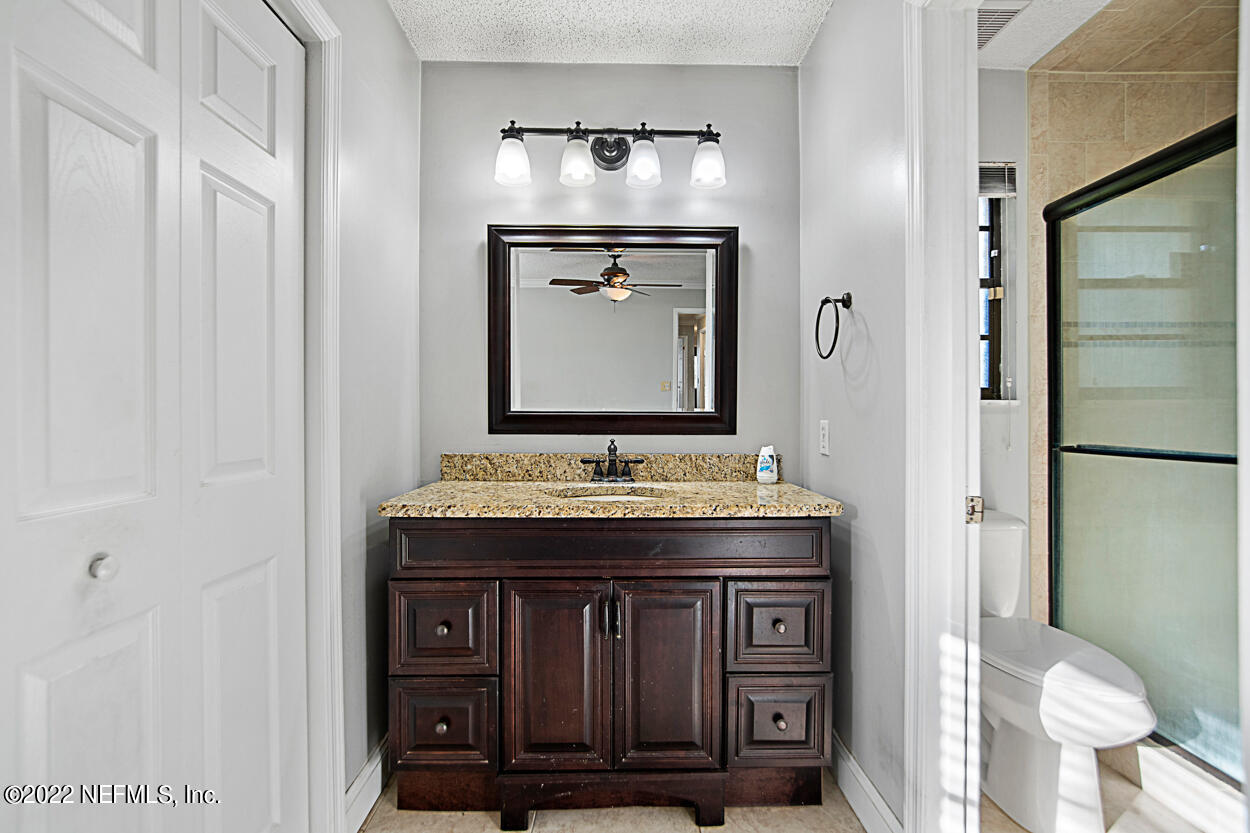 3759 Rustic Lane Jacksonville, FL 32217 - Photo 27 of 32 a bathroom with a granite countertop sink and a mirror