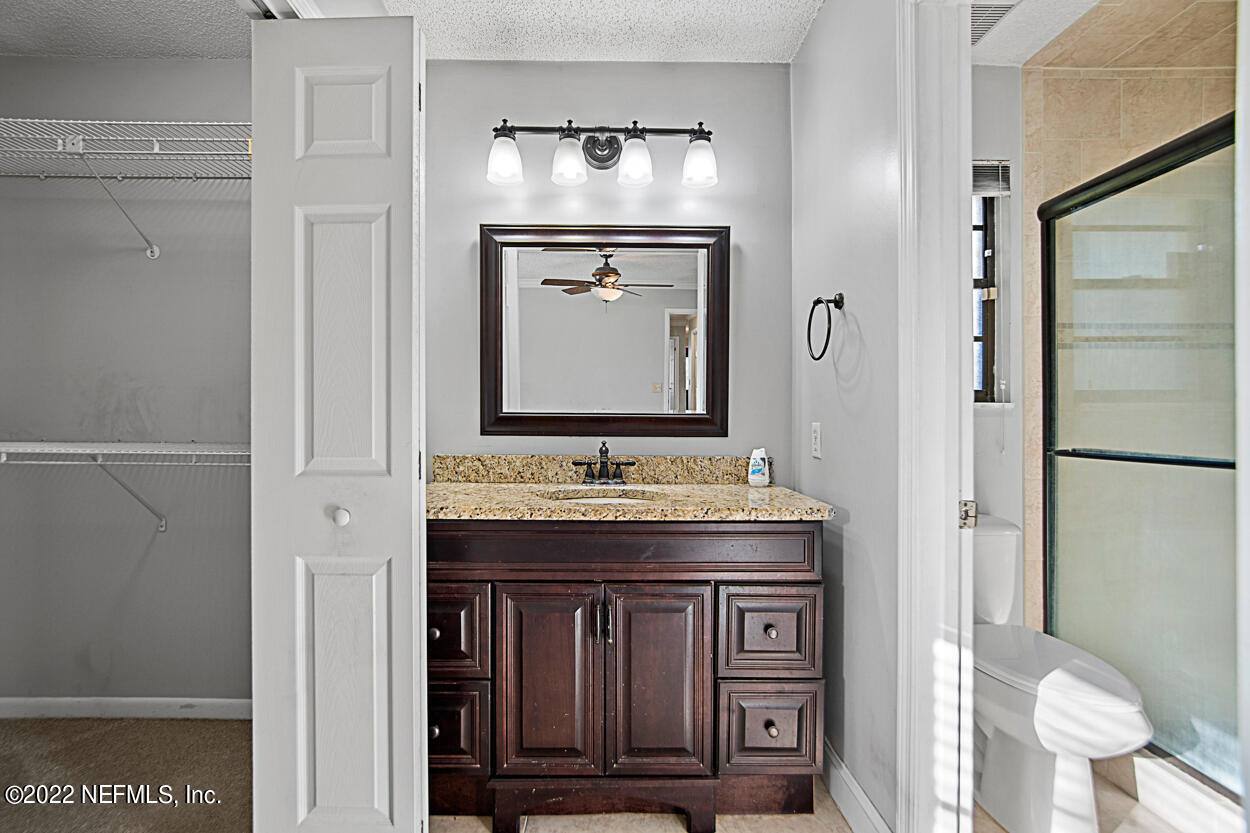 3759 Rustic Lane Jacksonville, FL 32217 - Photo 28 of 32 a bathroom with a granite countertop sink a toilet and a mirror