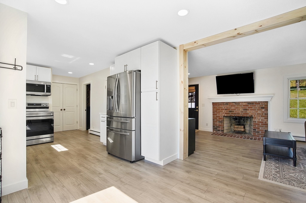 123 Stebbins Road Monson, MA 01057 - Photo 14 of 42 a kitchen with a refrigerator and a fireplace