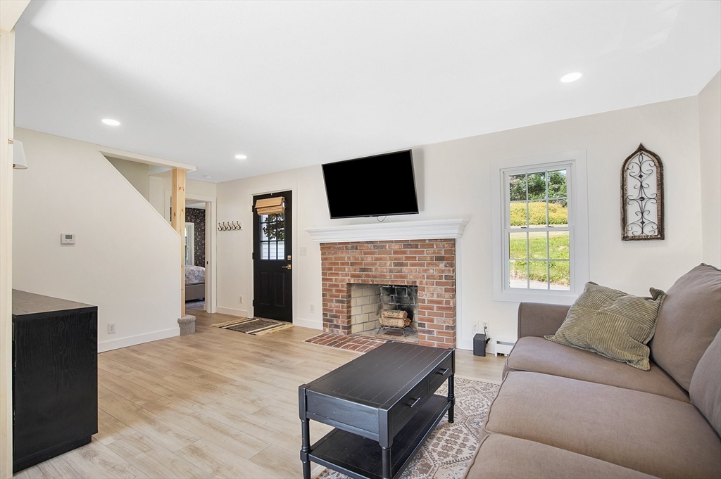 123 Stebbins Road Monson, MA 01057 - Photo 16 of 42 a living room with furniture a flat screen tv and a fireplace