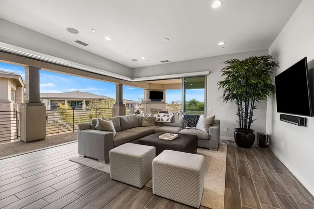 a living room with furniture flat screen tv and wooden floor