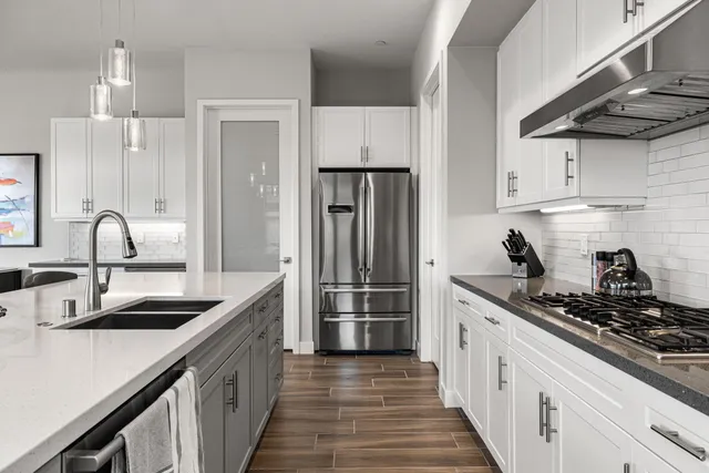 a kitchen with stainless steel appliances a sink stove and refrigerator