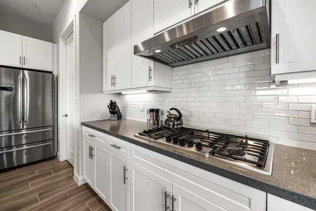 a kitchen with wooden cabinets stainless steel appliances and wooden floor