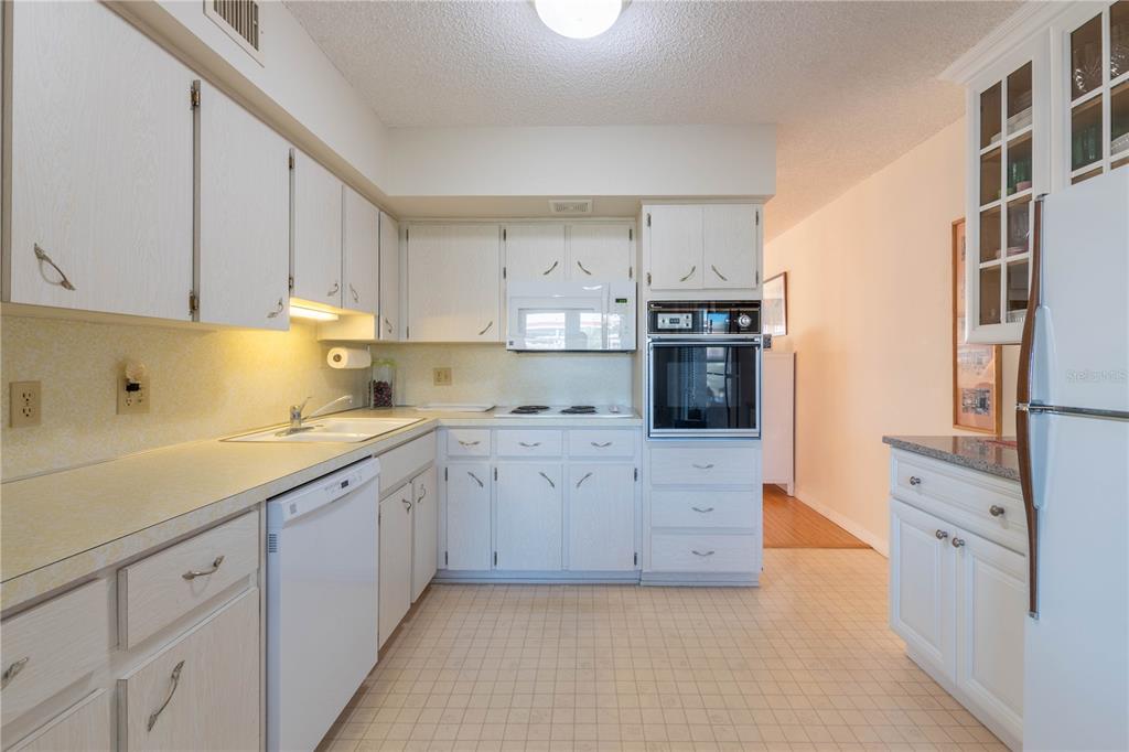 2310 Denmark Street, Unit 46 Clearwater, FL 33763 - Photo 12 of 44 a kitchen with granite countertop white cabinets and stainless steel appliances