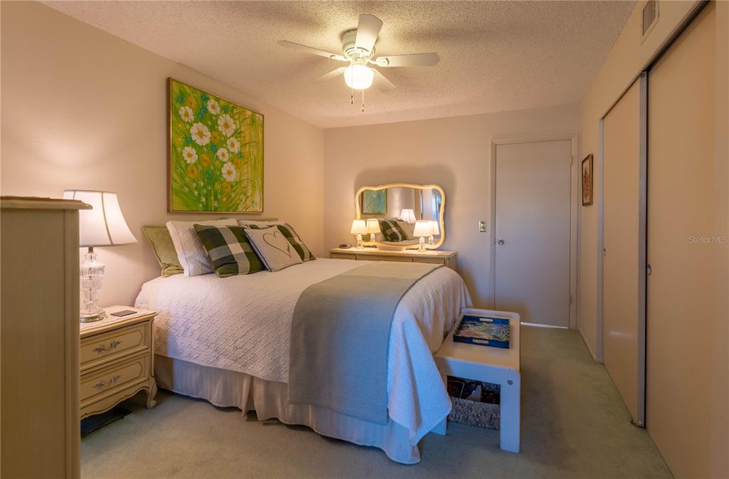 2310 Denmark Street, Unit 46 Clearwater, FL 33763 - Photo 17 of 44 a bedroom with a bed and a chandelier
