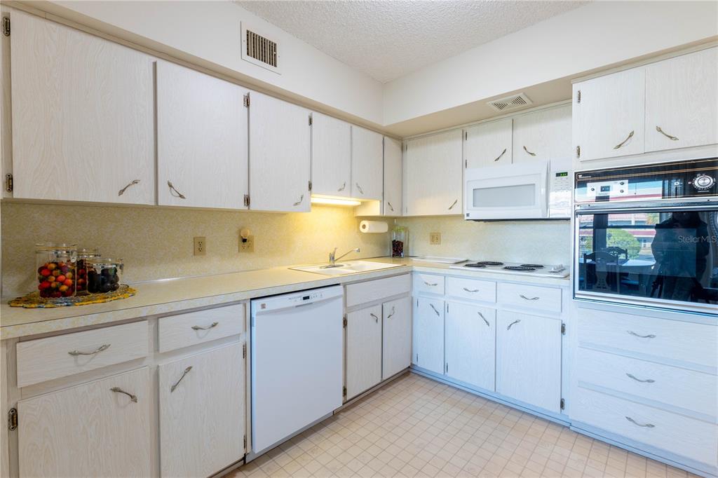 2310 Denmark Street, Unit 46 Clearwater, FL 33763 - Photo 10 of 44 a kitchen with white cabinets and white appliances