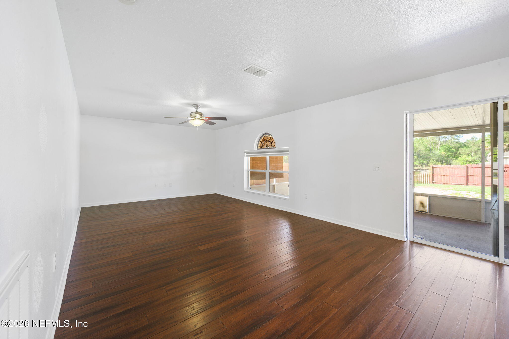 5470 Turkey Creek Road Jacksonville, FL 32244 - Photo 24 of 49 an empty room with wooden floor chandelier and windows