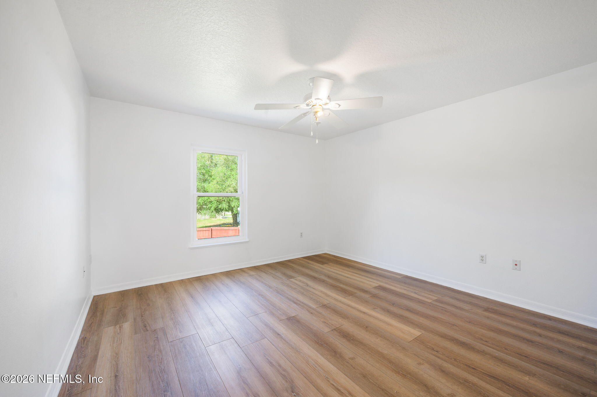 5470 Turkey Creek Road Jacksonville, FL 32244 - Photo 32 of 49 an empty room with wooden floor chandelier fan and windows