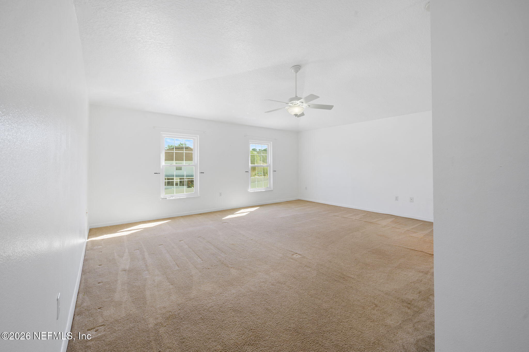 5470 Turkey Creek Road Jacksonville, FL 32244 - Photo 41 of 49 an empty room with windows and chandelier fan