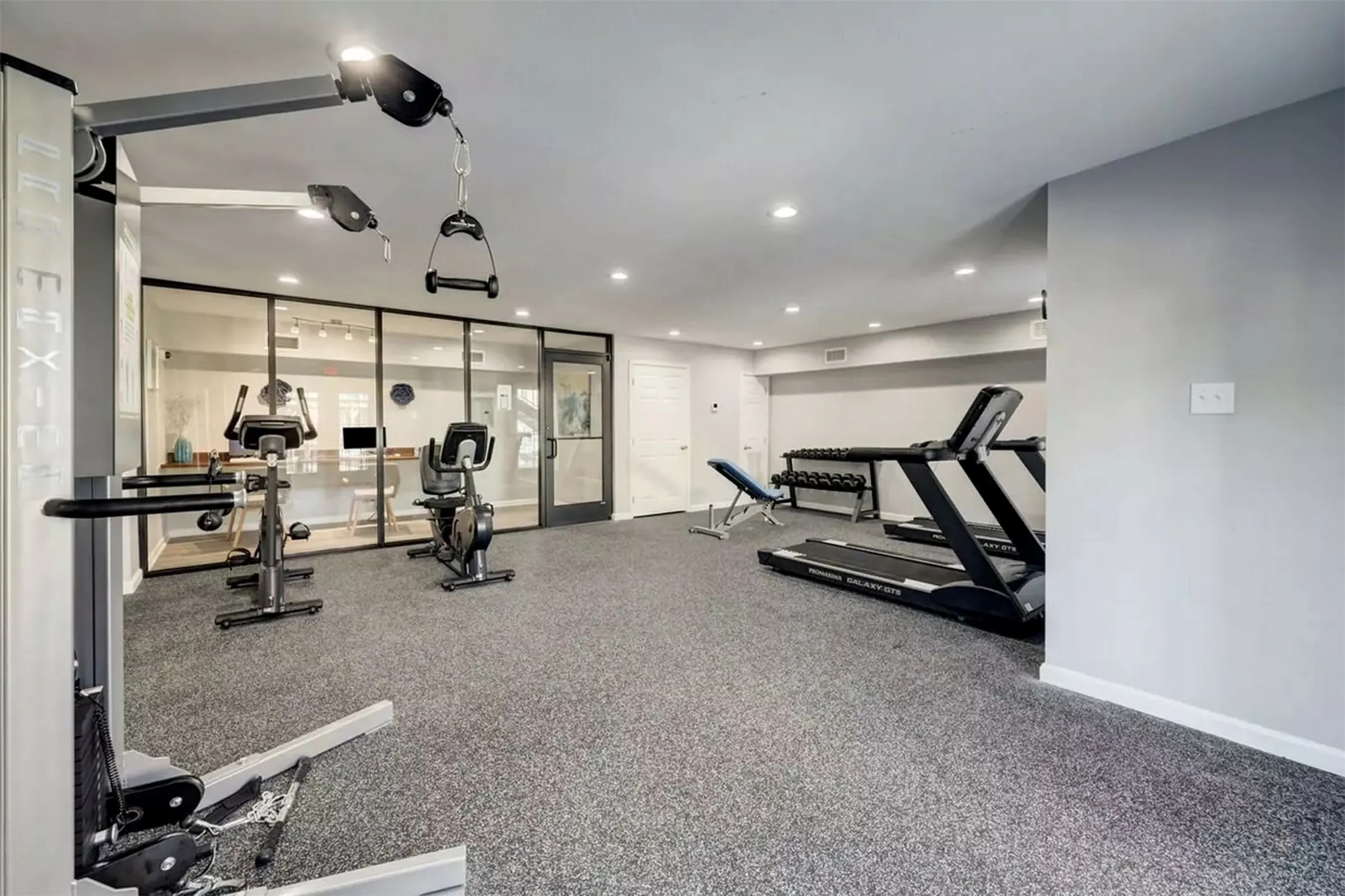 851 Threadneedle Street, Unit 704 Houston, TX 77079 - Photo 14 of 20 This fitness space features carpeting, recessed lighting, and a glass partition separating a smaller room with a window