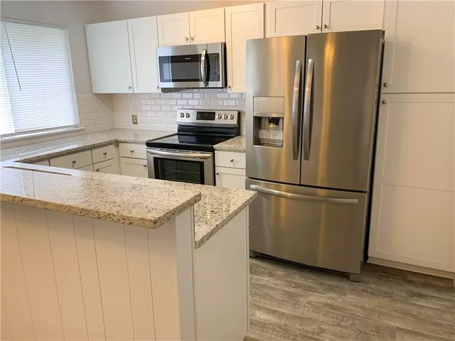 a kitchen with granite countertop stainless steel appliances and refrigerator