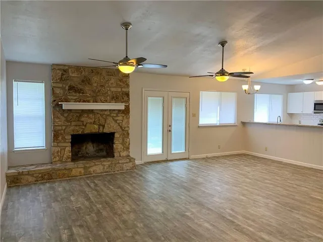 a view of an empty room with a fireplace and a window
