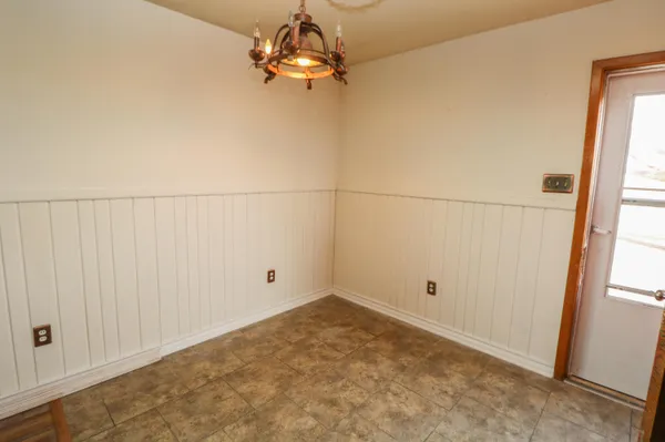 an empty room with chandelier fan