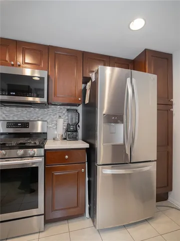 a metallic refrigerator freezer sitting inside of a kitchen