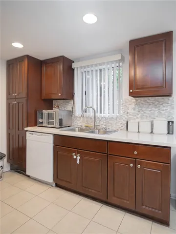 a kitchen with a sink window and cabinets