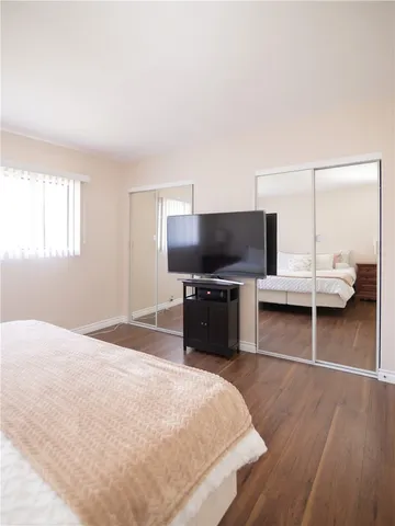 a bedroom with a bed and a flat screen tv