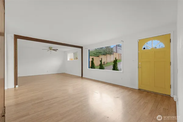 a living room with furniture a lamp and a large window